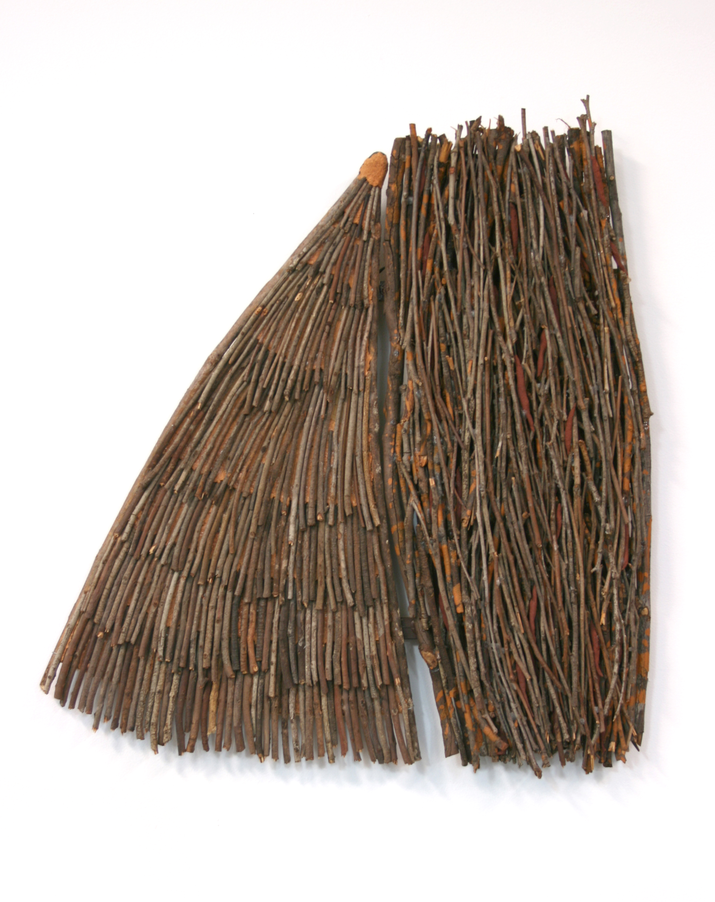 A sculpture of tightly packed eucalyptus twigs against a white background
