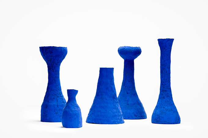 Image of five blue shaped vases on white background