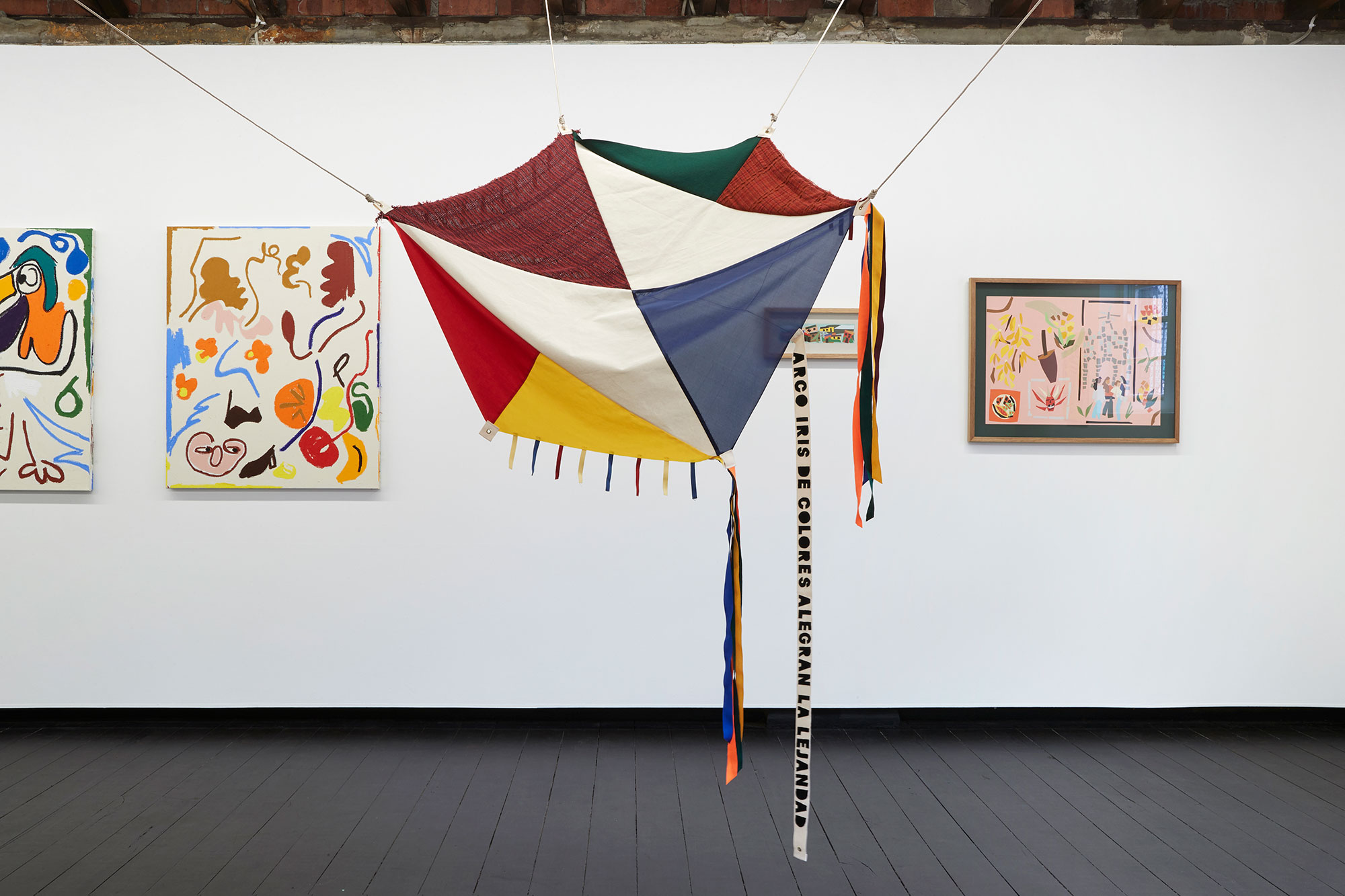 a colourful rainbow kite in an art gallery