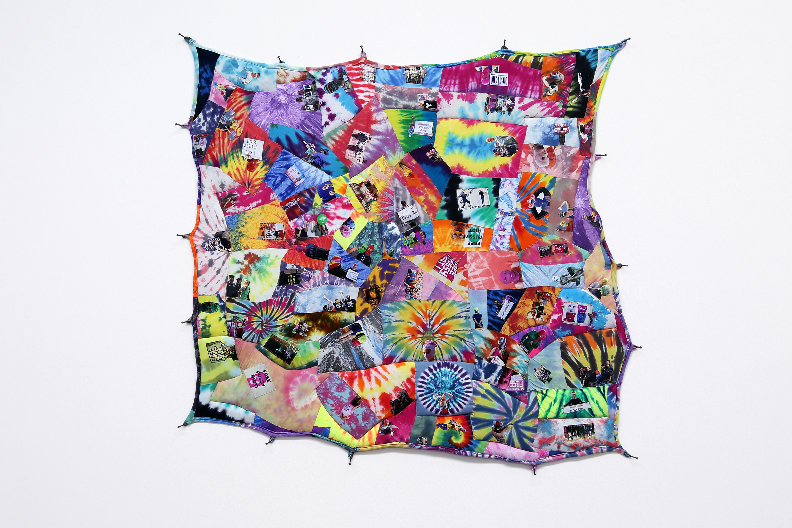 Patchwork quilt made with tie-dye fabric and stitched photographs of protestors