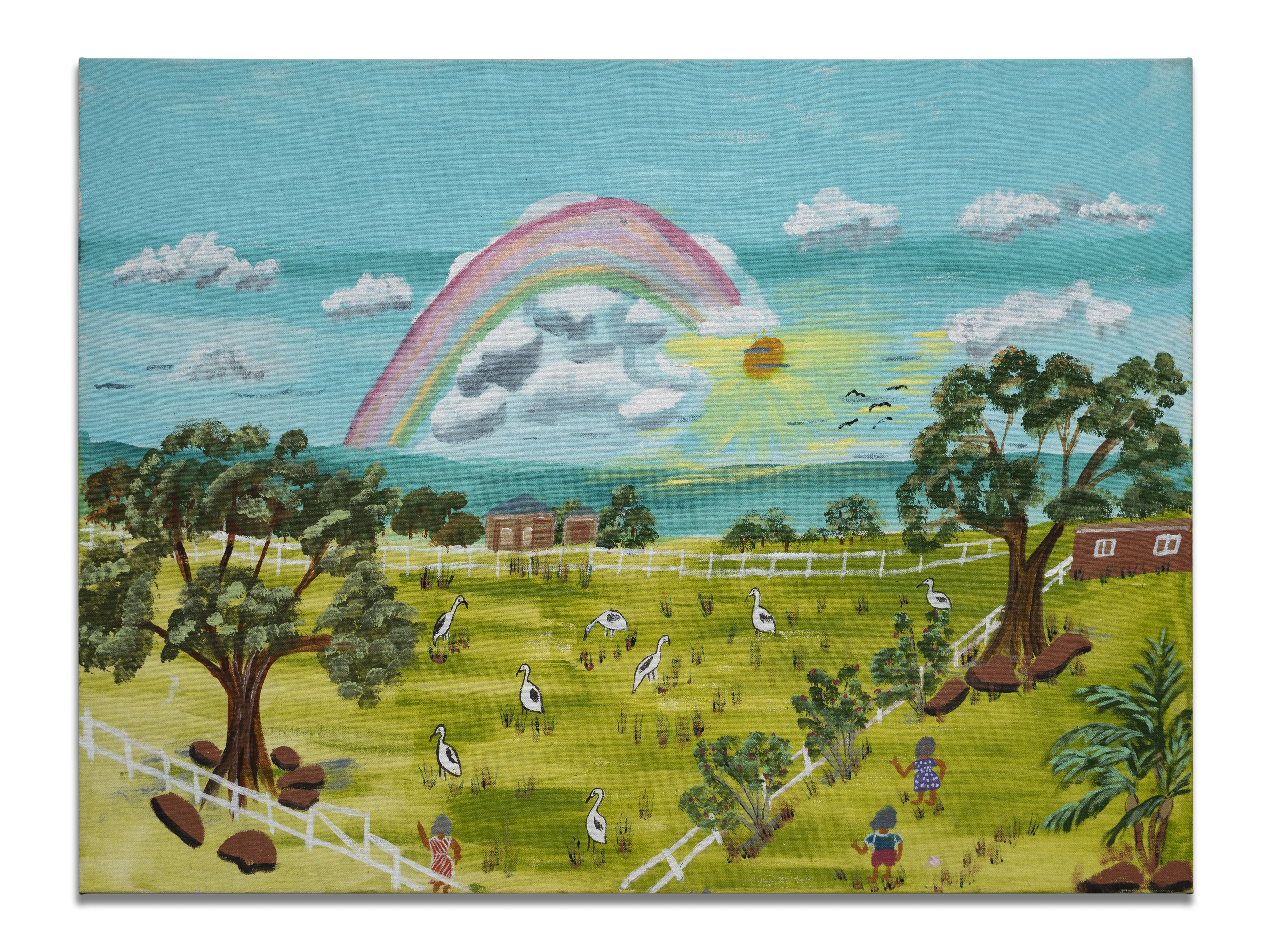 A rainbow arches across a bright blue sky