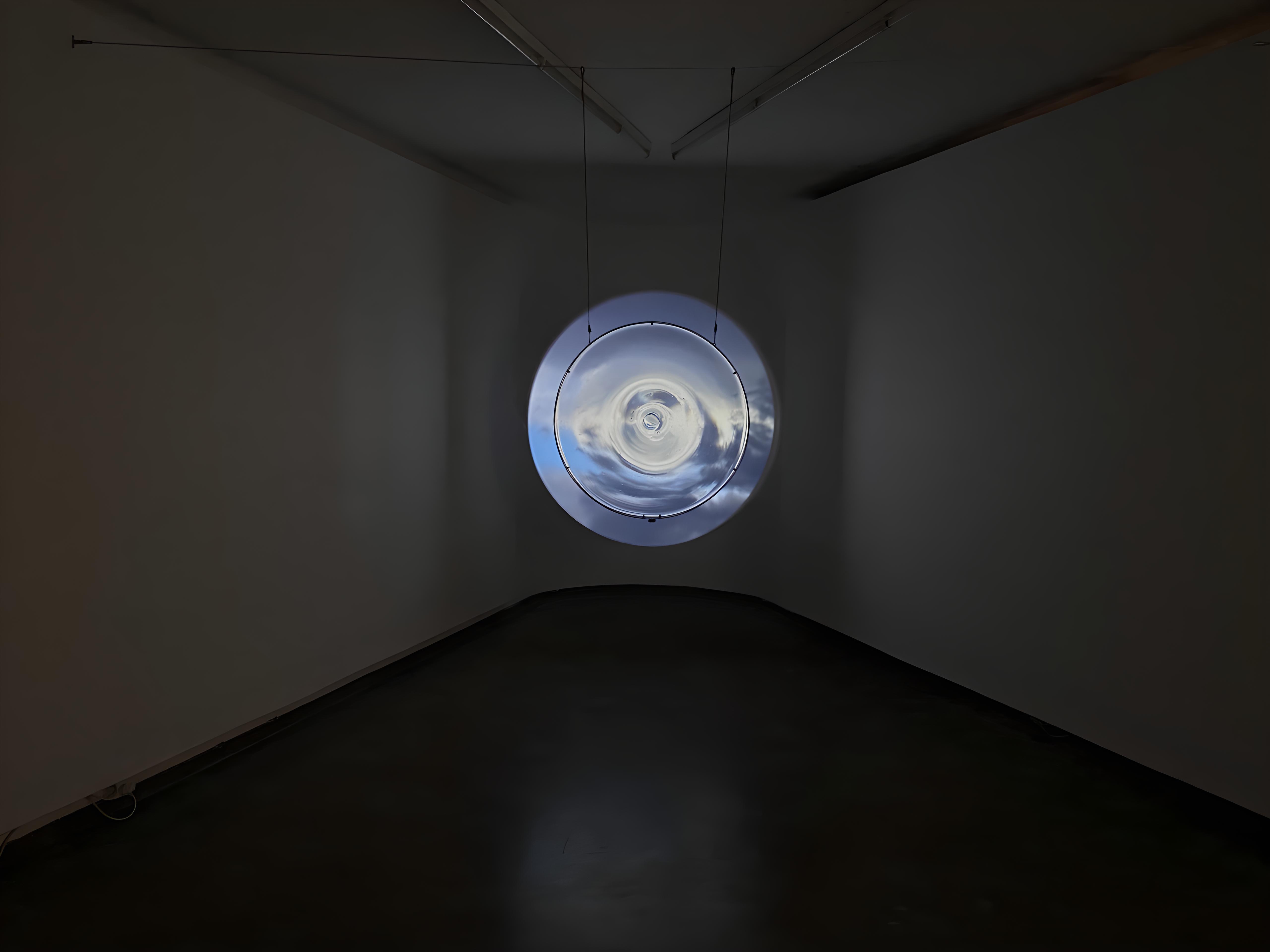 A circular projection of a sky in a dark room