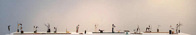 Image of 20 different small objects made from different material in a horizontal line