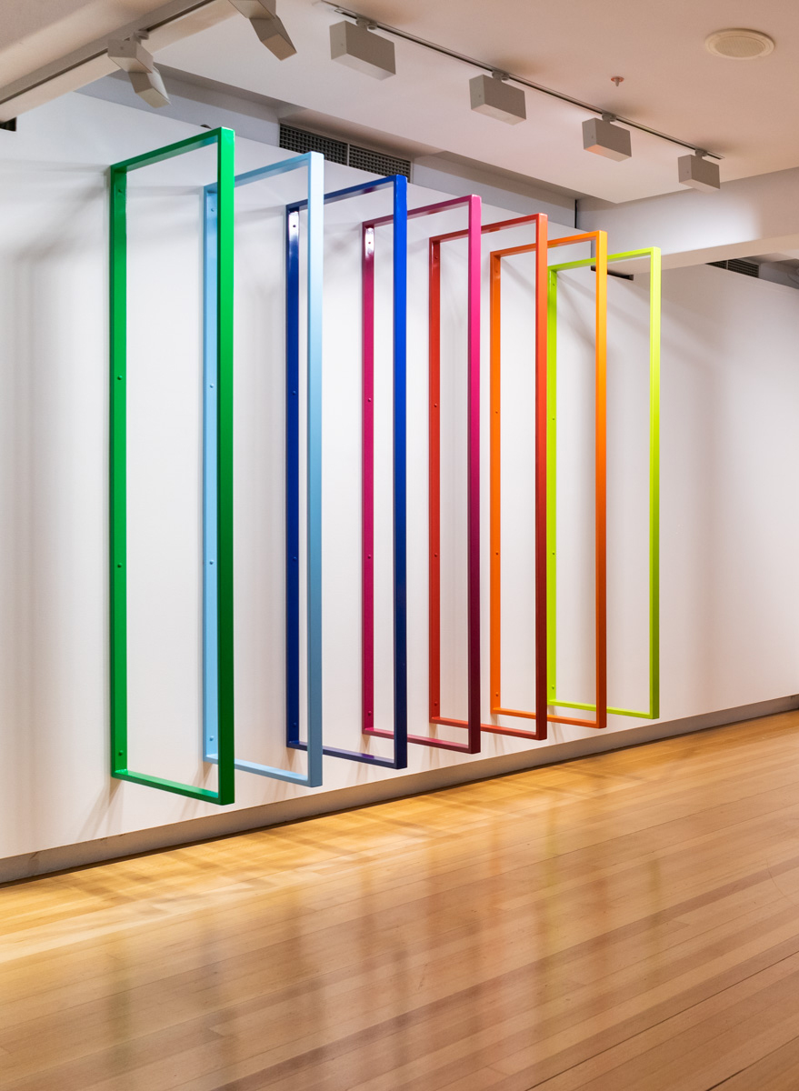A sculpture of seven brightly coloured steel rectangles protruding from the wall.