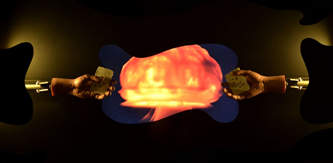 Abstract image of two robotic hands holding a card with a yellow/orange fire ball in the middle of the image