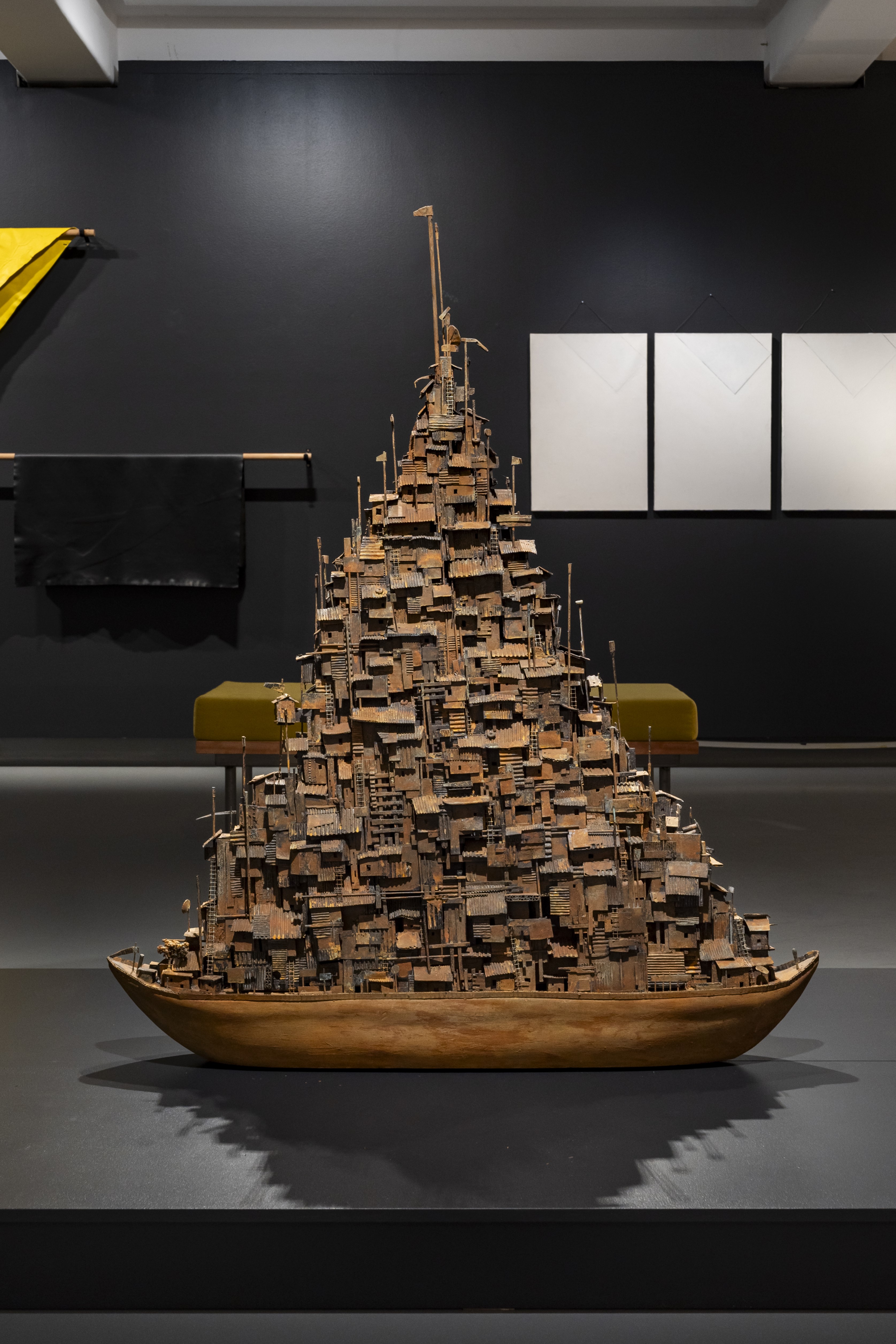 A cardboard sculpture of a boat with makeshift housing